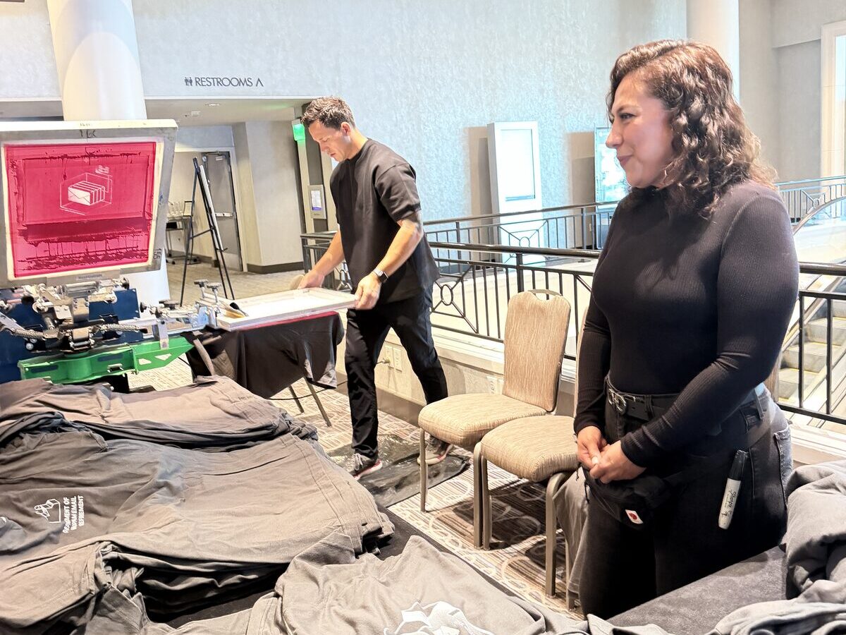 Printed shirts staged on mezzanine tables at the bank leadership summit onsite printing deployment
